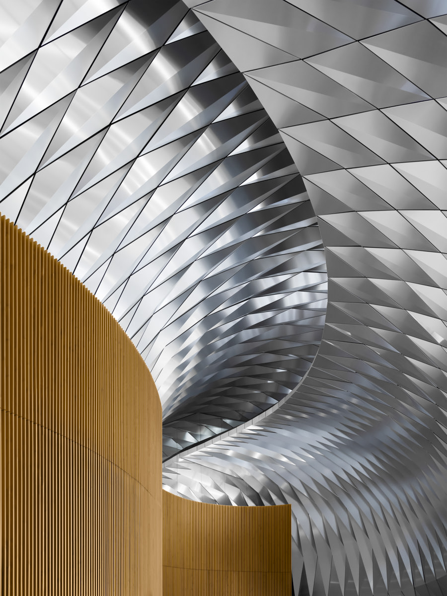 A detailed interior shot of a modern Sydney building showing metallic ceiling textures and curved wooden accents.